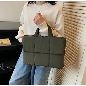 Deep green quilted handbag with minimalist fabric texture and secure zipper close