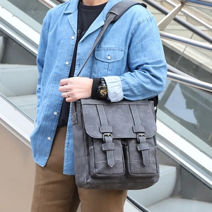 Outdoor shot of dark gray vintage men's crossbody bag with double buckle straps