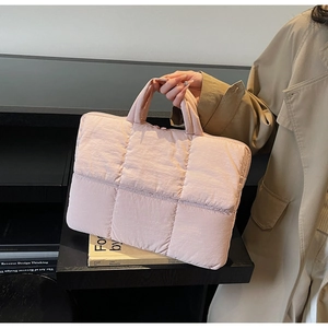 Macro detail of soft quilted diamond pattern on pink laptop tote bag for women