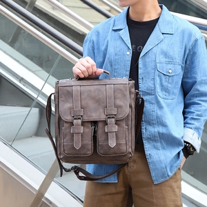 Detail of dark brown vintage messenger bag with double zipper pockets and textured leather