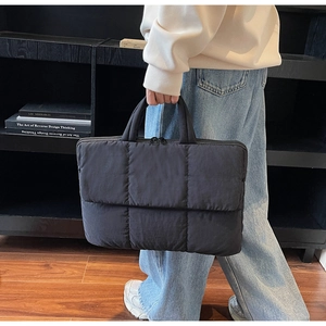 Detailed view of dark grey quilted laptop bag with durable padded fabric handles