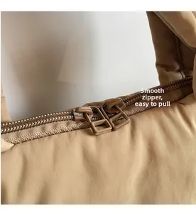Detail view of smooth double zipper closure on khaki quilted puffer handbag