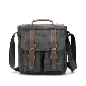 Vintage dark grey messenger bag with brown trim and front pockets on white background