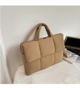 Close-up of quilted khaki laptop handbag featuring padded fabric and dual handles