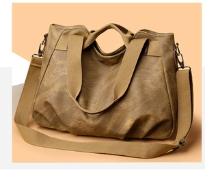 Detail of vintage brown canvas tote bag with woven strap and metallic hooks