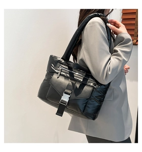 Détail du sac fourre-tout noir brillant en duvet avec boucle et grande capacité interne