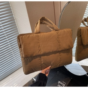 Detail of coffee quilted nylon handbag with square stitching and comfortable handle