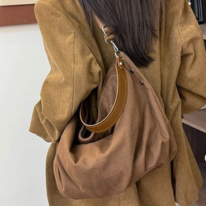 Retro canvas hobo tote bag in brown featuring leather handles for a vintage commuter look
