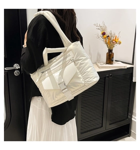 Vue détaillée d'un sac cabas matelassé blanc avec poche à boucle et bandoulière rembourrée