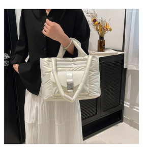 Détail du sac fourre-tout matelassé blanc avec boucle en métal et bandoulières bouffantes