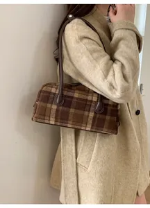 Brown checkered wool shoulder bag on model wearing a beige coat for autumn style
