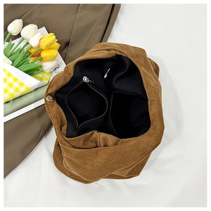 Interior detail of brown suede tote bag showing magnetic buckle and black zipper pocket