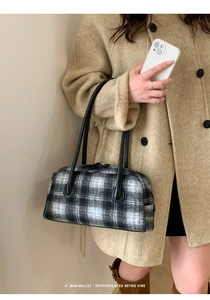Classic black and white checkered tweed handbag styled with a beige coat in a street shot