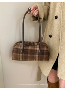 Detail of retro brown plaid wool texture and metal zipper on Boston handbag