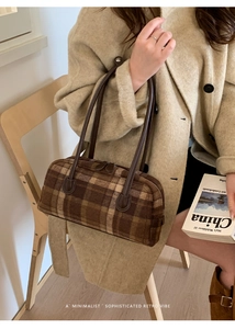 Detailed close-up of retro brown plaid handbag texture with leather handles and autumn vibe