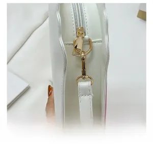Close-up of polished gold hardware and swivel hook on white leather shoulder bag