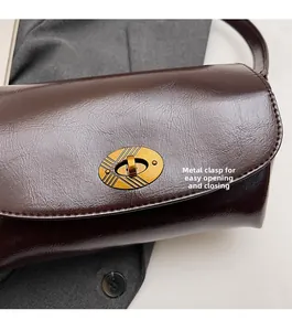 Detailed close-up of a vintage wine red leather bag with golden textured twist lock