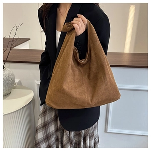 Detail of suede tote bag with knotted strap showing the soft texture and minimal design