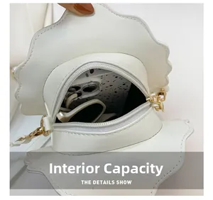 Internal view of shell-shaped white PU leather bag showing phone and sunglasses storage