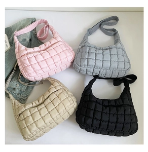 Flat lay view of quilted puffy handbags in pink, gray, beige, and black colors