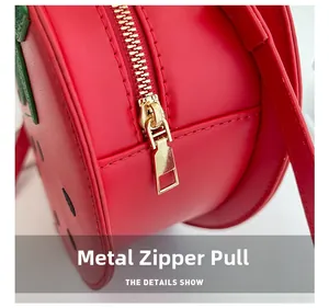 Close-up of strawberry bag detail with premium golden zipper hardware and leather texture
