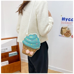 Detail of creative cupcake shaped crossbody bag with blue cream top and pink bow