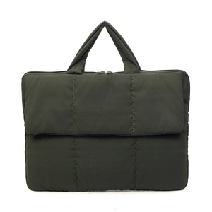 Quilted green commuter handbag with top handle and front pocket on white background