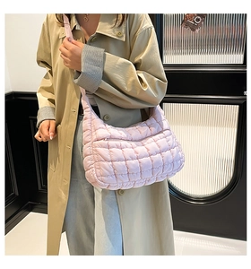 Pink quilted cloud bag with puffy grid pattern shown on a model in khaki trench coat