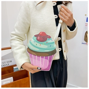 Detail of creative cupcake-shaped shoulder bag featuring cherry detail and leather strap