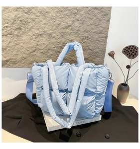 Détail du sac fourre-tout en duvet matelassé bleu clair avec texture et bandoulière large