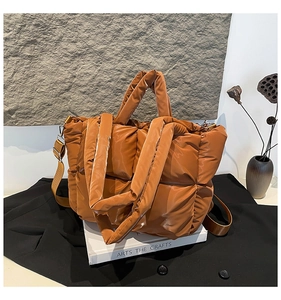 Gros plan d'un sac cabas matelassé marron avec texture en nylon brillant sur un décor