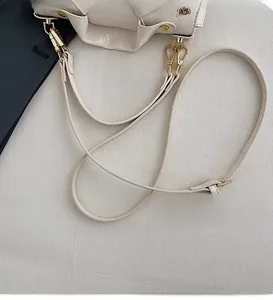 Detail of adjustable cream leather shoulder strap with premium gold metal hardware and buckles