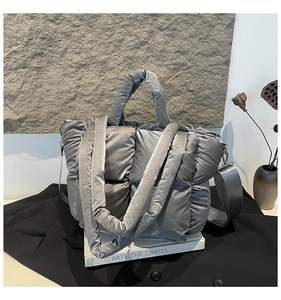 Détail du sac à main matelassé gris avec finition satinée et large bandoulière amovible