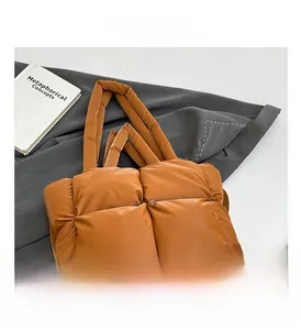 Vue détaillée de la texture matelassée et du tissu marron brillant de ce sac cabas