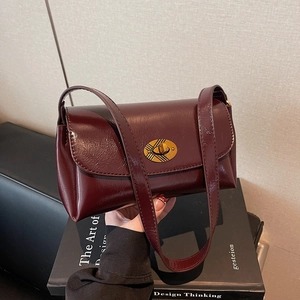Vintage burgundy square shoulder bag with gold rotary lock and polished leather texture
