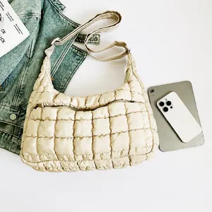 Detail showing the beige quilted fabric and smooth texture of the padded cloud bag