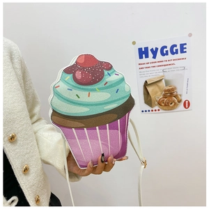 Detailed view of cupcake-shaped crossbody bag featuring glitter mint frosting and cherry top