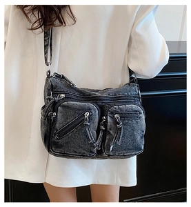 Détail du sac bandoulière en denim gris avec poches utilitaires et fermetures éclair