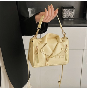 Close-up of cream motorcycle jacket style crossbody bag with metal rivets and zippers