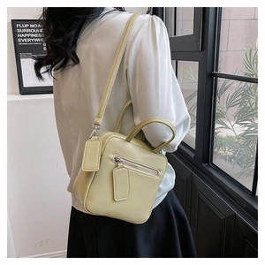 Light green minimalist square crossbody bag with side-view handle and matte leather finish
