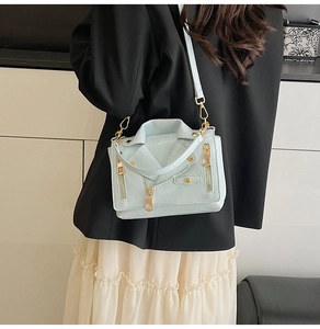 Detailed view of mint green moto jacket bag with golden zippers and biker style design