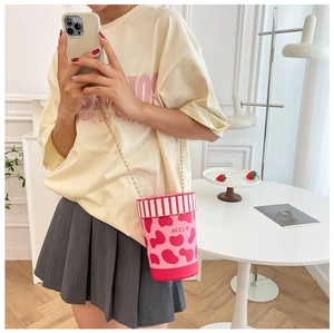 Detail der rosa Milchbecher-Tasche mit Kettengurt und Erdbeer-Deko im Lifestyle-Set