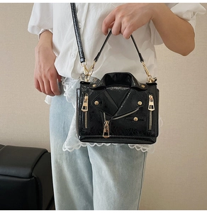 Detail of black faux leather biker jacket bag with gold zippers and cracked texture