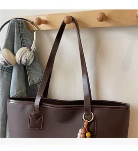 Macro shot of dark brown tote bag showing textured canvas and leather strap detail