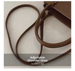 Close-up of adjustable leather strap and textured pebble grain on dark brown tote bag
