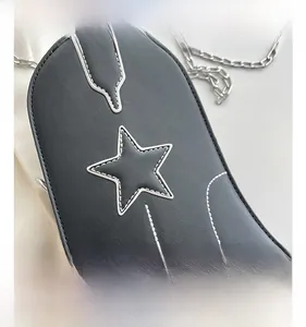 Détail du sac en cuir noir avec surpiqûres blanches et motif d'étoile argentée