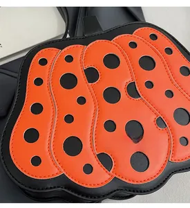 Dettaglio della borsa a forma di zucca con motivo a pois arancioni e cuciture in pelle
