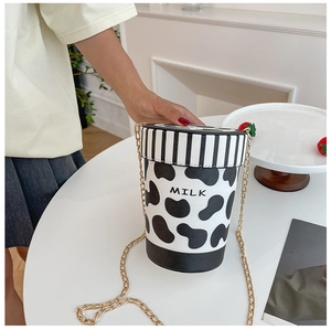 Detail der Eimertasche mit Kuhmuster, goldener Kette und aufgedrucktem MILK-Schriftzug