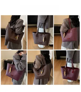 Detail view of large leather tote bags in dark brown and wine red with beaded charms