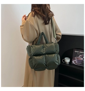 Vue détaillée du sac matelassé vert foncé avec rembourrage carré et finitions argentées